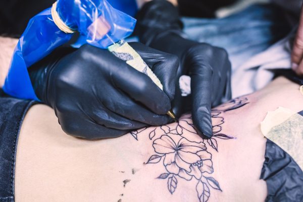 hands-making-tattoo-with-machine